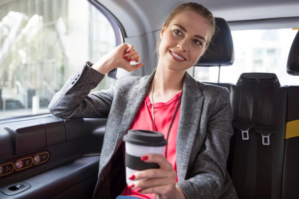 Passagère VTC souriante en train de parler avec le chauffeur