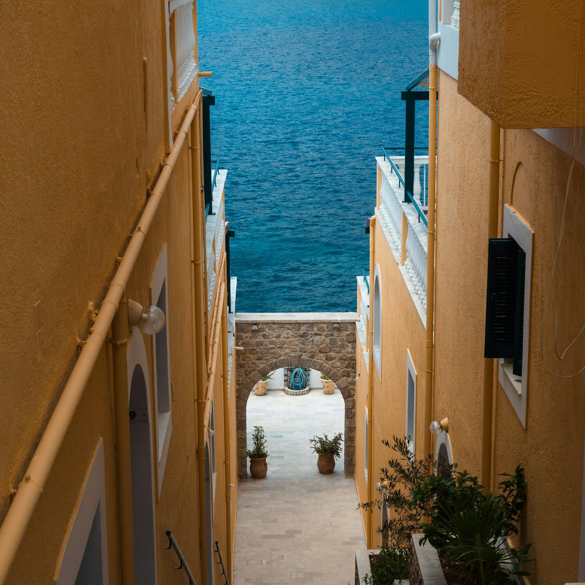 Vue d'une ruelle en Grèce avec la mer au dernier plan. découverte de la langue italienne par Thibaud lors d'un moment passé à l'hôtel. Lingua Italiana